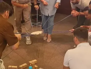 Ekip, merkeze bağlı iplerle ahşap blokları kaldırıp üst üste diziyor.